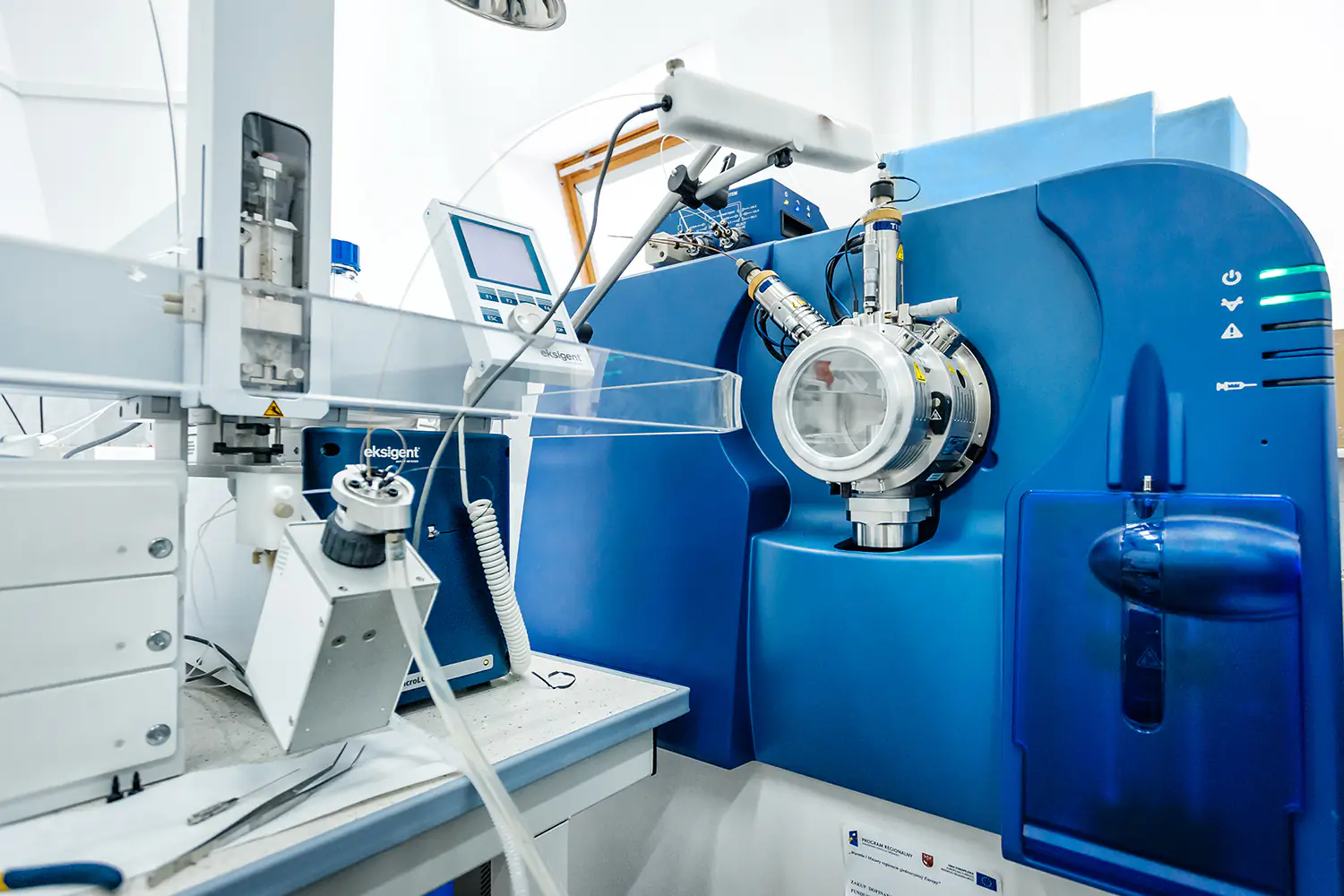 Zbliżenie na zaawansowany spektrometr mas Sciex połączony z systemem chromatograficznym w laboratorium.